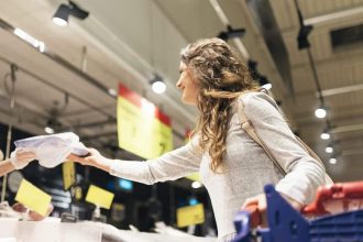 Femme choisissant du poisson frais dans un supermarché