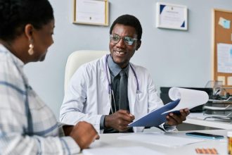 Médecin de garde souriant consultant une patiente dans un cadre médical